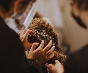 Candid photo of hairstylist pinning a boho-style formal updo